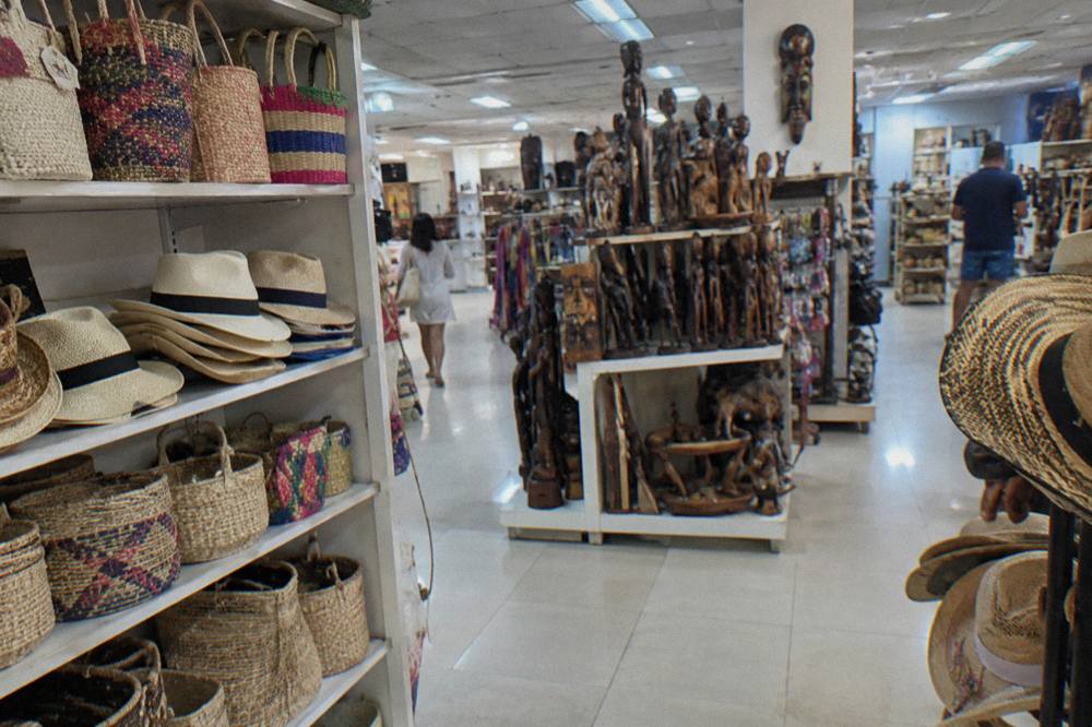 Duty-free shop shelves stocked with rum bottles and souvenirs in a bright airport store