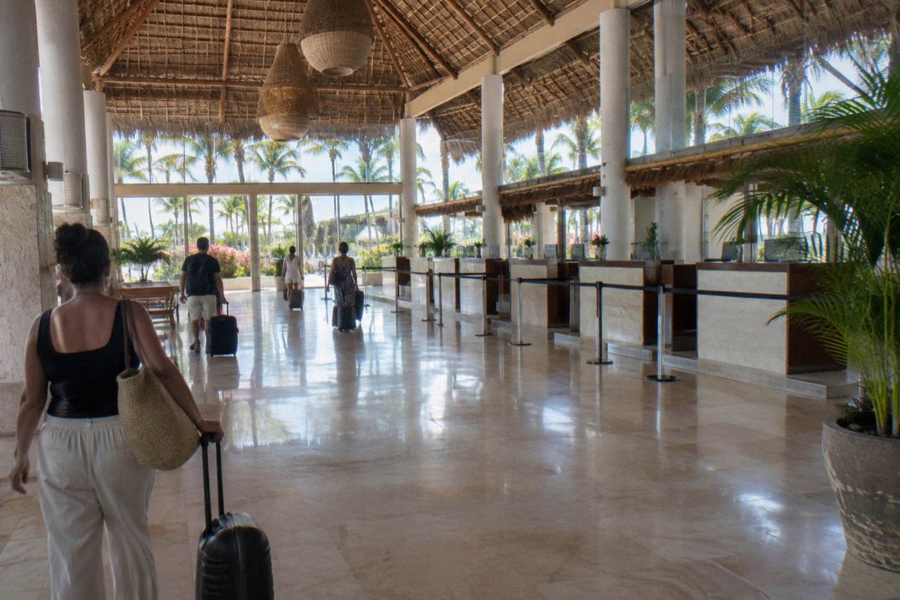 Departure hall of a Caribbean airport with check-in counters and morning light through the windows