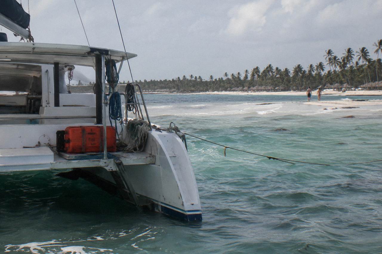 Catamaran anchored in clear shallow water beside a natural sandbar off the Bavaro coast