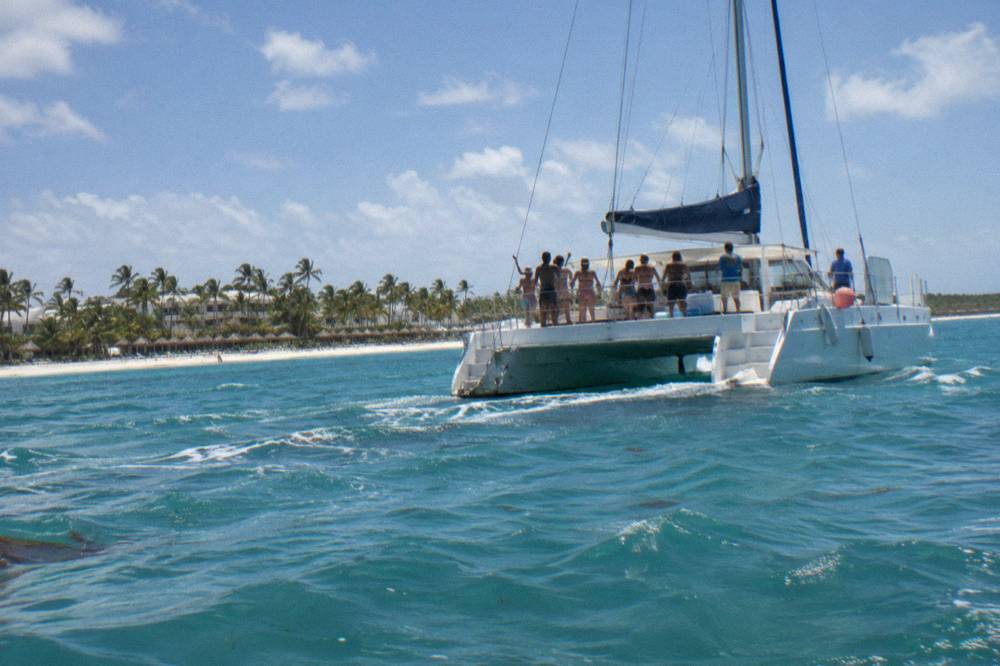 Crowd of adult guests dancing on the open deck of a catamaran