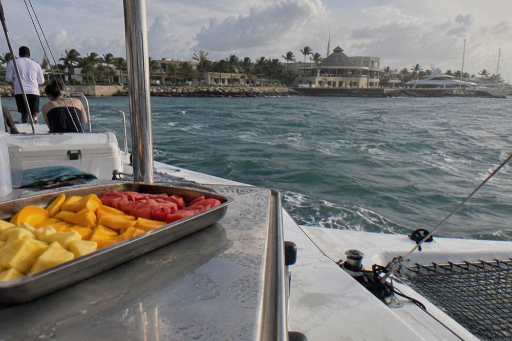 Open bar drinks and tropical fruit arranged on a boat deck table