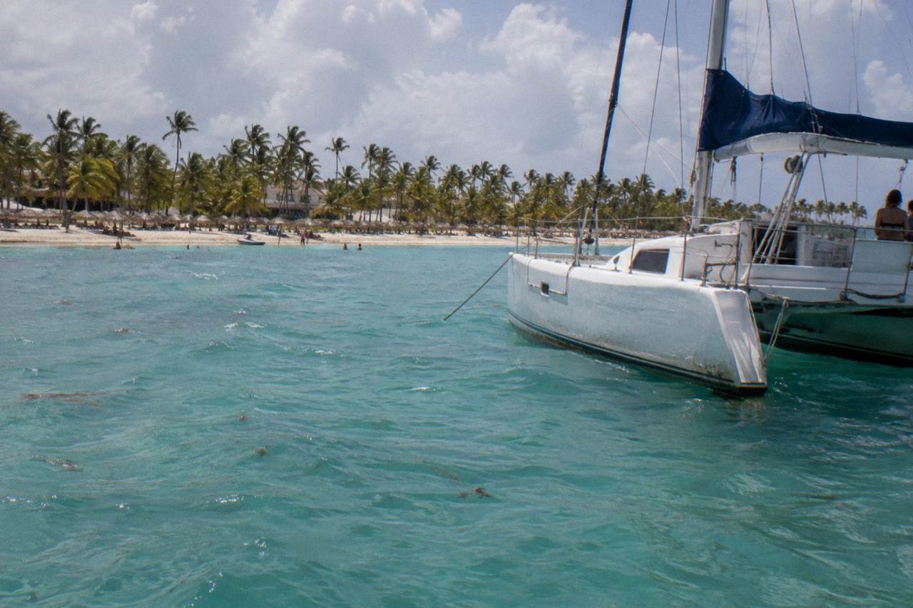 Decorated catamaran anchored over calm turquoise water near the Bavaro coastline