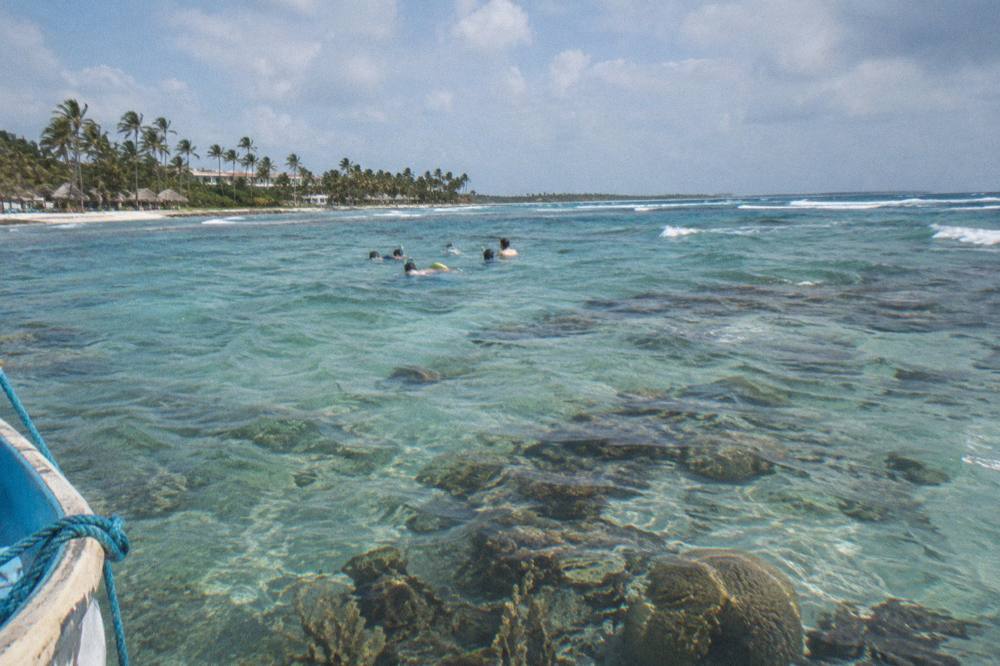 Snorkelers in calm clear water over a shallow reef near Punta Cana