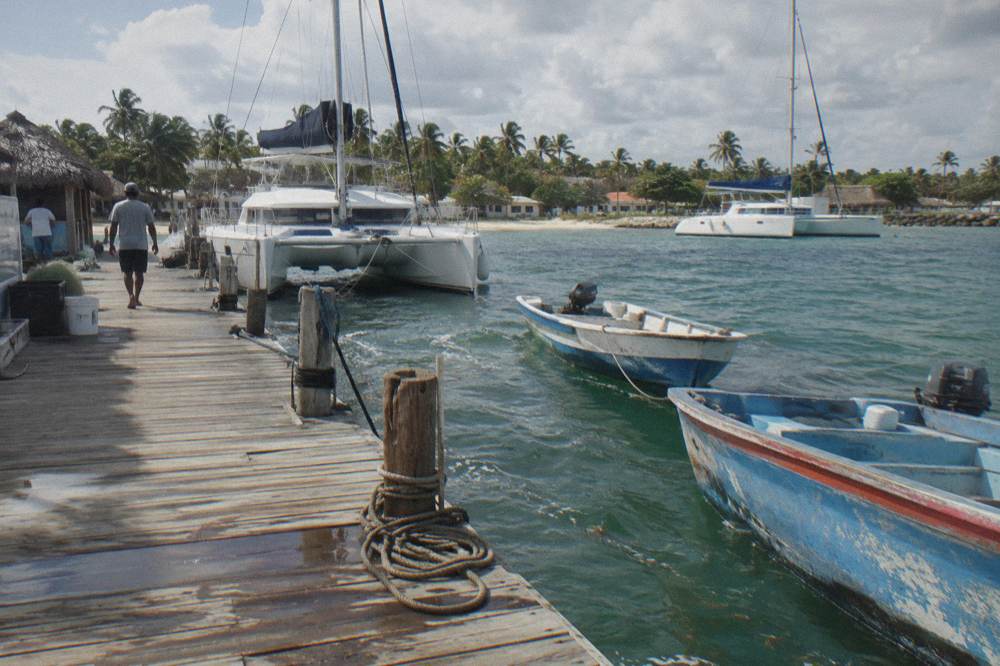 Wooden dock with moored catamarans in calm morning water