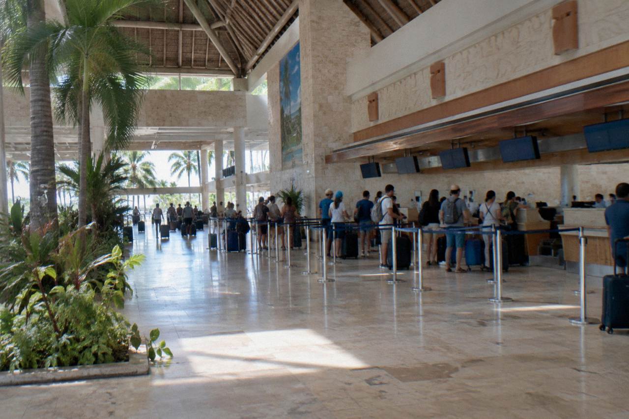 Departure hall of Punta Cana airport with travelers at check in counters
