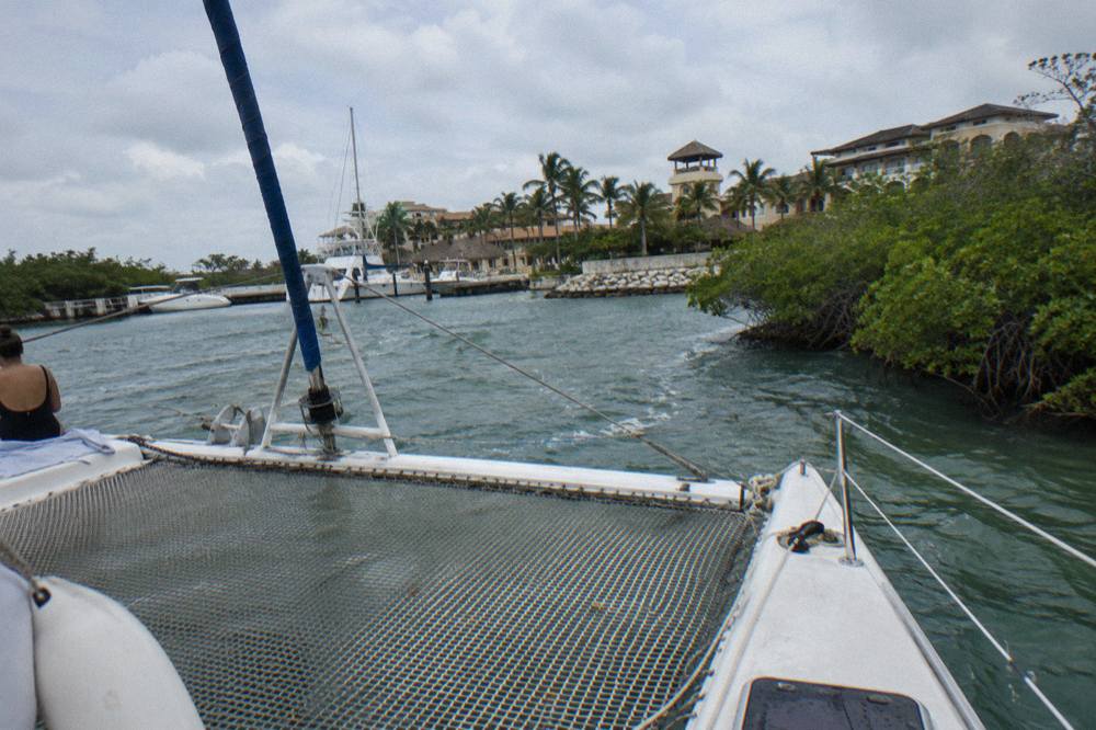 Catamaran deck with seating and netting over clear shallow water