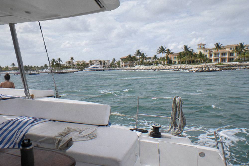 Open deck of a catamaran with lounge seating and calm sea beyond