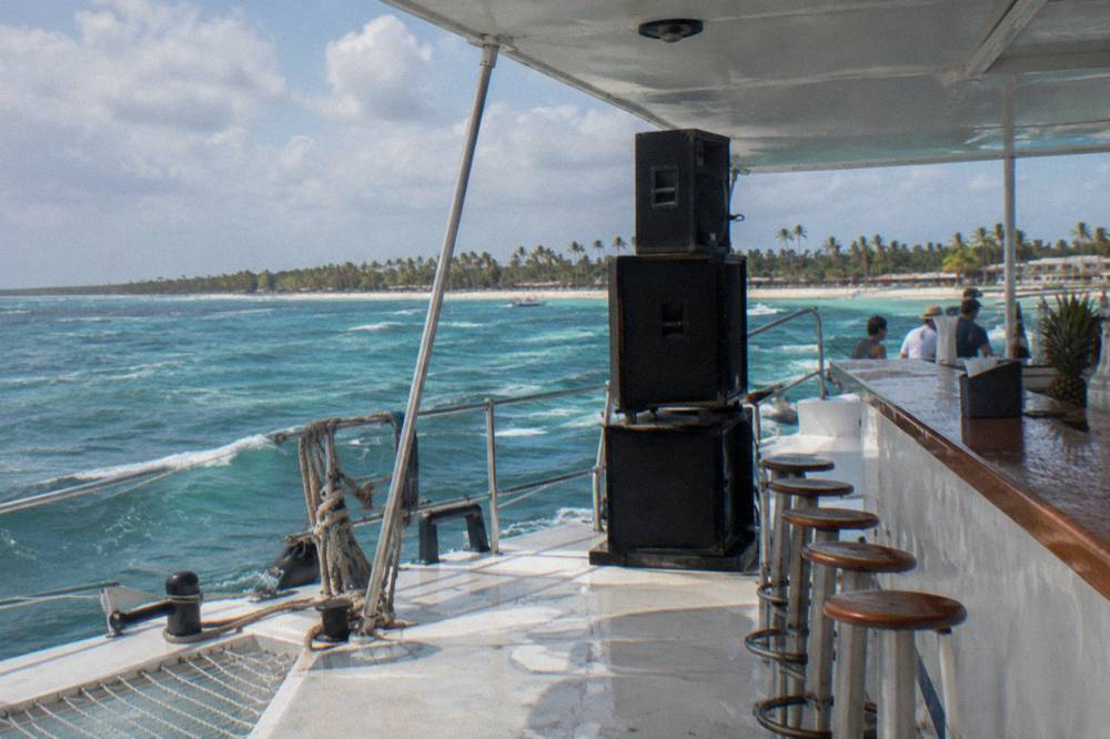 Catamaran deck with speakers and drink station under an afternoon sky on the Bavaro coast