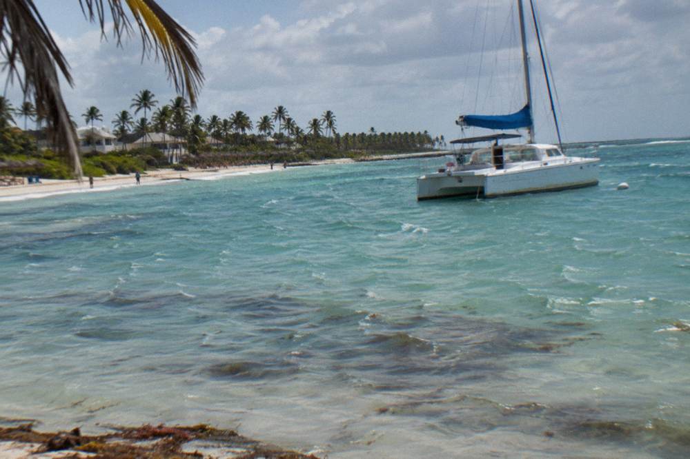 Catamaran anchored in shallow turquoise water at a natural pool off the Bavaro coast