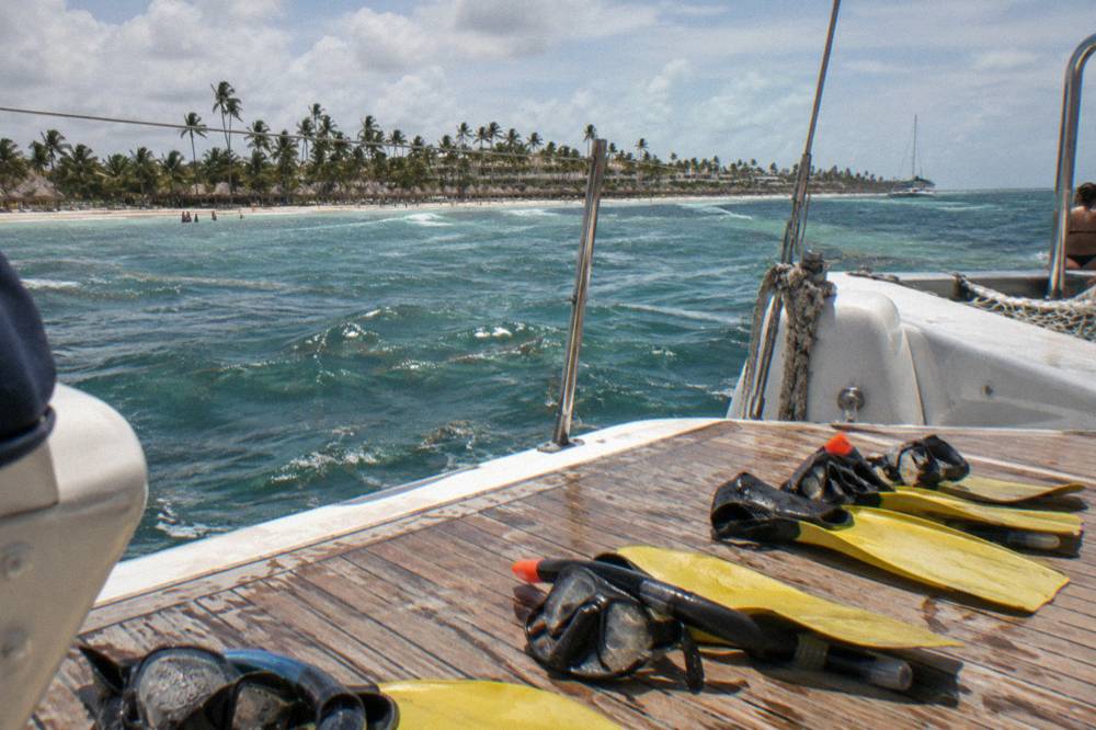 Snorkel gear and fins laid out on the deck of a catamaran