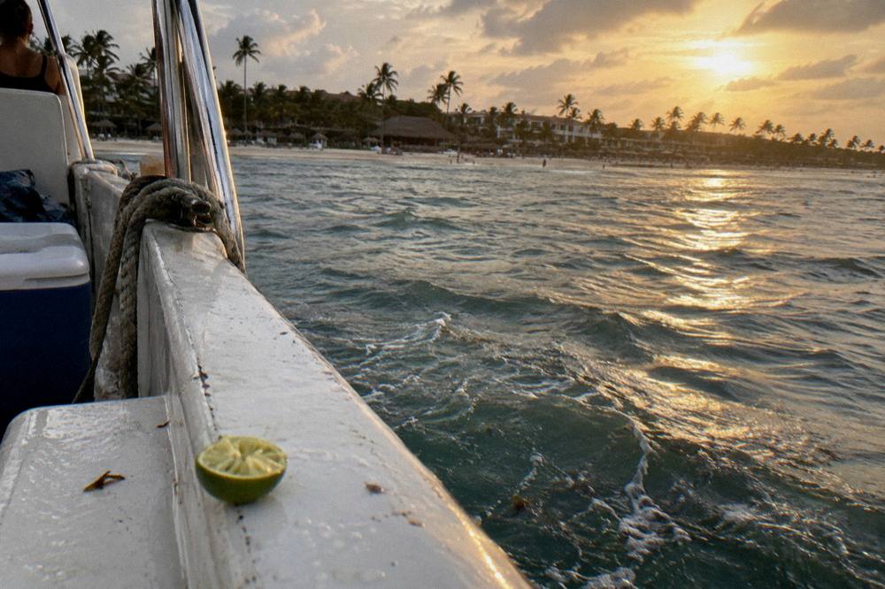Boat deck at golden hour with calm sea and towels drying on a rail